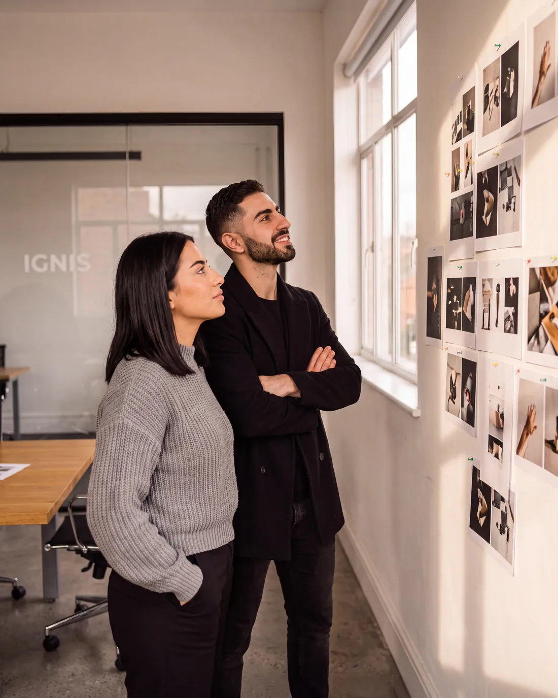 Two of the Ignis team standing back from a wall of finished printed work